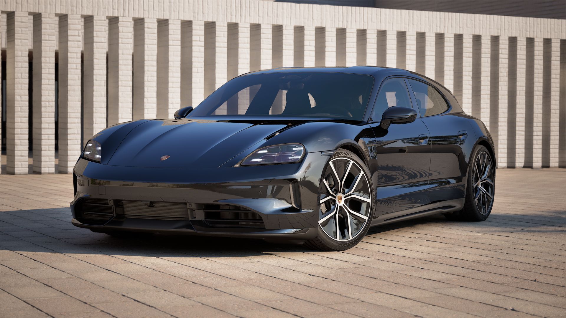 Außenansicht von Taycan Sport Turismo Black Edition mit der Vorderseite und der linken Seite des Fahrzeugs